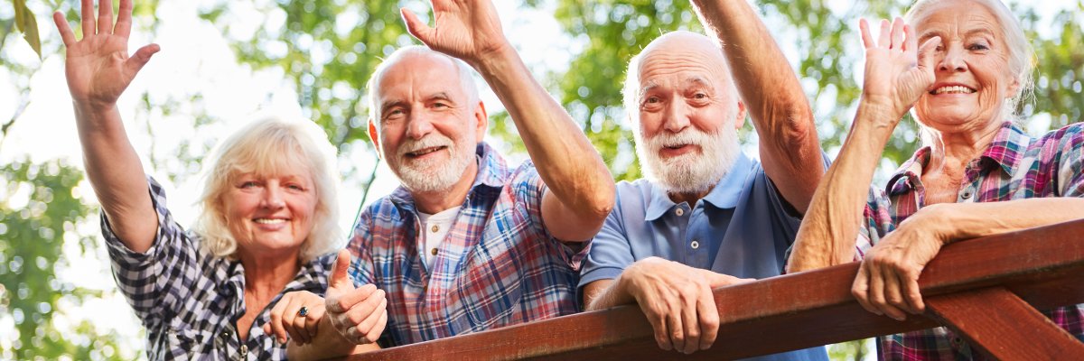 Happy seniors wave from a bridge
