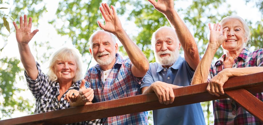 Happy seniors wave from a bridge